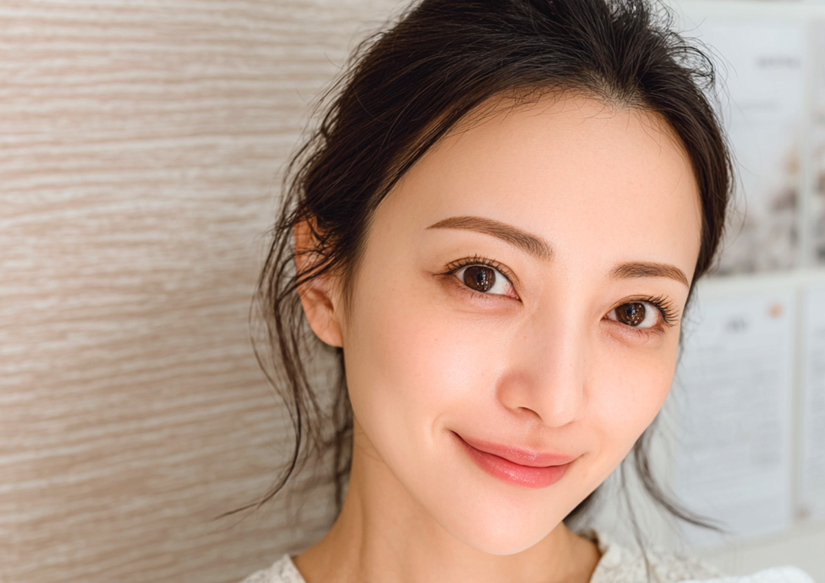 アートメイクで整えられた眉と目元を持つ女性のクローズアップ。自然な仕上がりで柔らかな表情を見せている